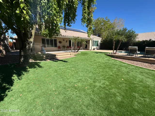 a front view of a house with yard patio and swimming pool