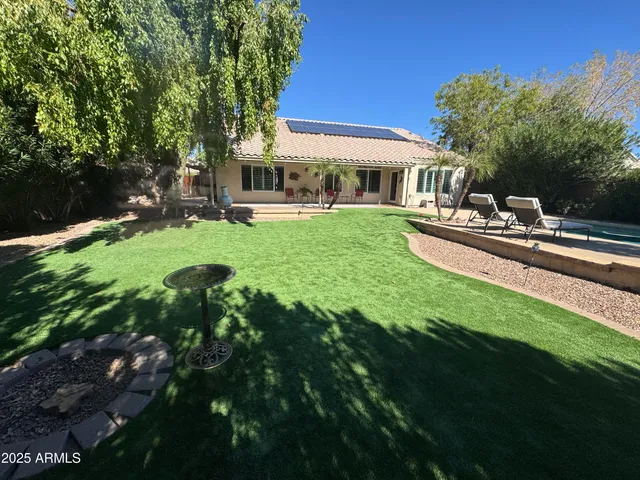 a view of a house with backyard sitting area and garden