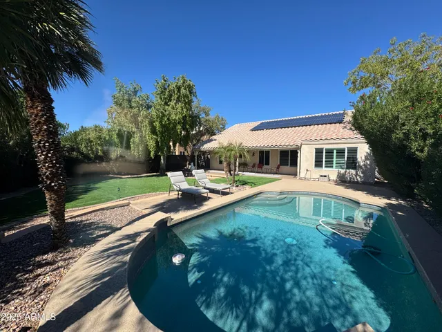 a view of a house with swimming pool and a yard