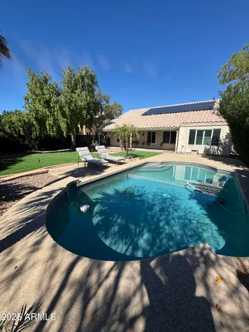 a view of a house with backyard and sitting area