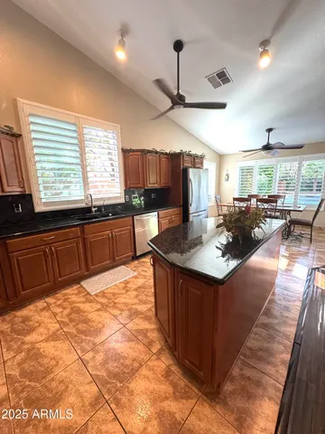 a kitchen with stainless steel appliances granite countertop a sink a stove and a wooden floors
