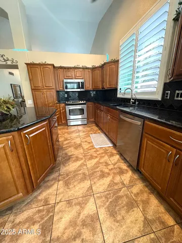 a kitchen with stainless steel appliances kitchen island granite countertop a sink and cabinets