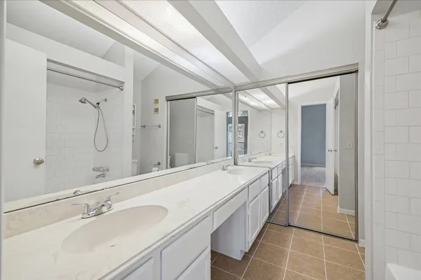 a spacious bathroom with a double vanity sink mirror and shower
