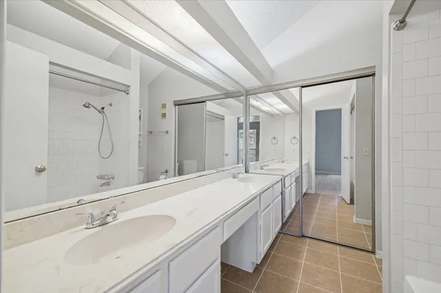 a spacious bathroom with a double vanity sink mirror and shower