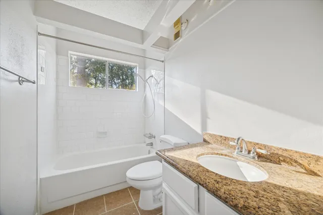 a bathroom with a granite countertop sink toilet and shower