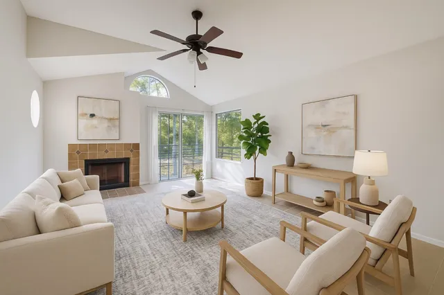 a living room with furniture a fireplace and a large window