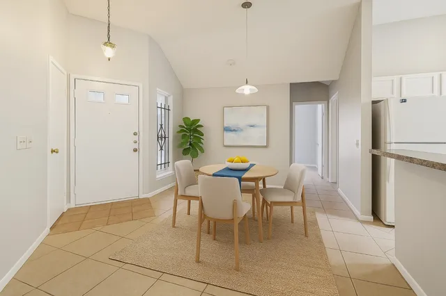 a dining room with furniture and a refrigerator
