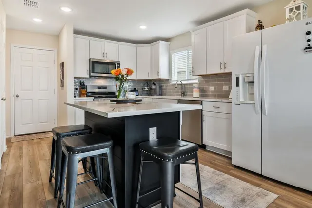 a kitchen with stainless steel appliances granite countertop a sink a stove a refrigerator and cabinets