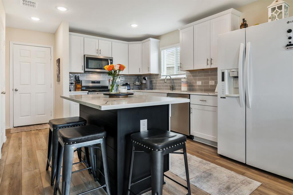 1228 Viscount Street Haslet, TX 76052 - Photo 1 of 28 a kitchen with stainless steel appliances granite countertop a sink a stove a refrigerator and cabinets
