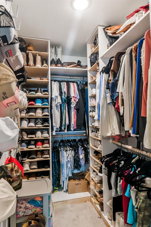 1228 Viscount Street Haslet, TX 76052 - Photo 18 of 28 a view of walk in closet with clothes and shoes