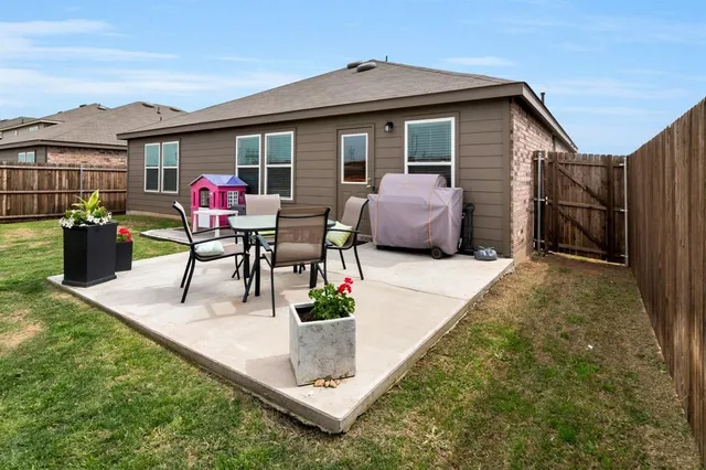 a view of a house with a backyard and chairs
