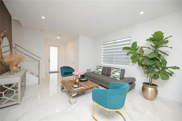 a kitchen with stainless steel appliances a sink a stove top oven a refrigerator a sink and dishwasher with wooden floor