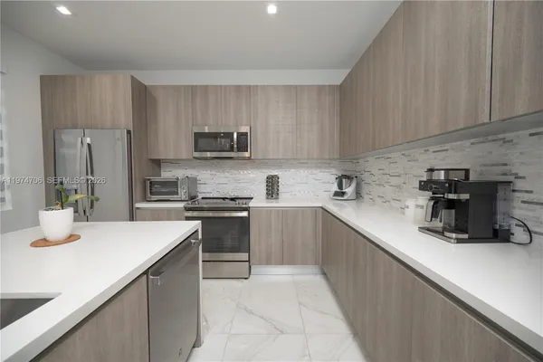 a kitchen with stainless steel appliances granite countertop a sink stove and cabinets