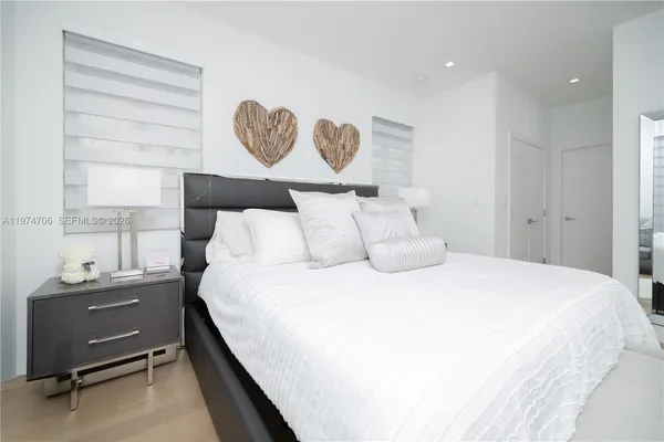 a bedroom with a bed and painting on the wall