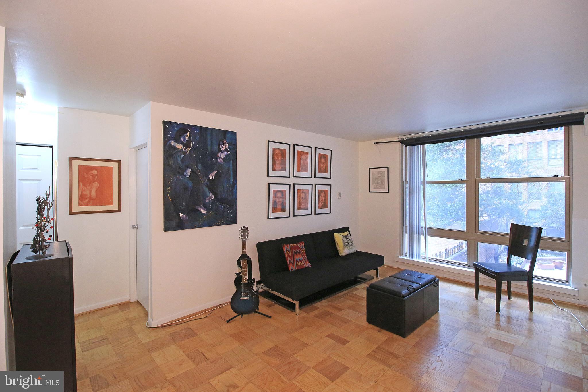 1260 21st Street Northwest, Unit 207 Washington, DC 20036 - Photo 2 of 16 a living room with furniture and a window