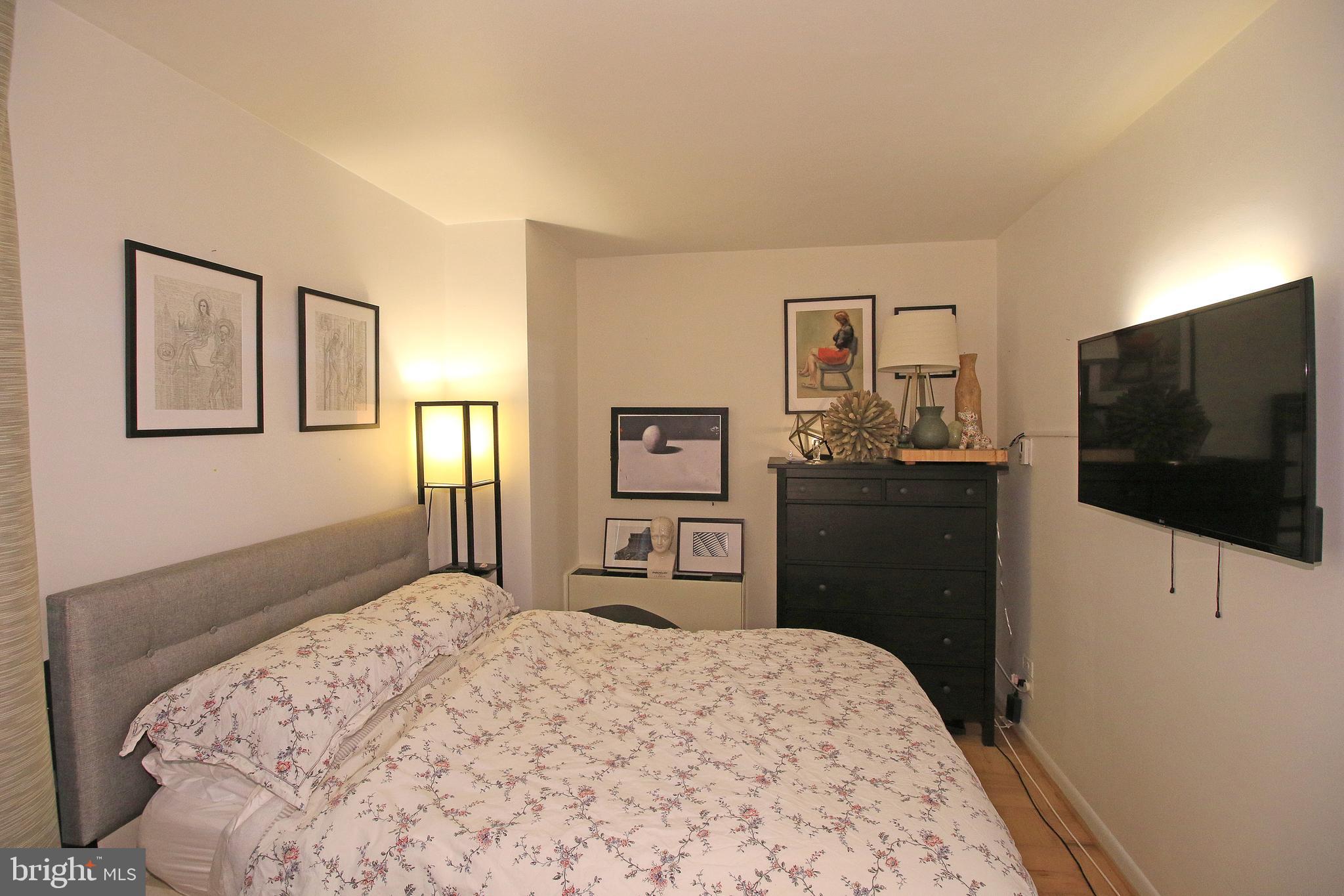 1260 21st Street Northwest, Unit 207 Washington, DC 20036 - Photo 8 of 16 a bedroom with a bed and a flat screen tv