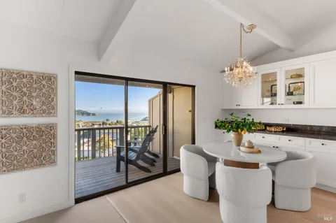 a dining room with furniture a chandelier and wooden floor