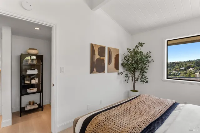 a bedroom with a bed and a potted plant