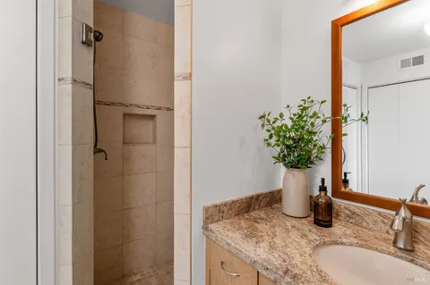 a bathroom with a granite countertop sink and a mirror