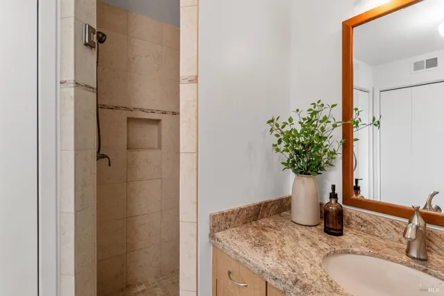 a bathroom with a granite countertop sink and a mirror