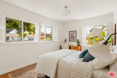a bedroom with bed and a potted plant