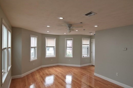 73 Hamilton Street Boston, MA 02125 - Photo 4 of 21 a view of empty room with wooden floor and fan