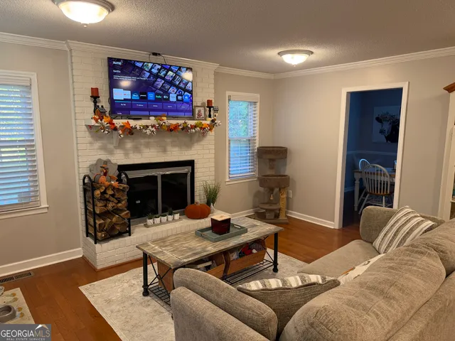 a living room with furniture a flat screen tv and a fireplace