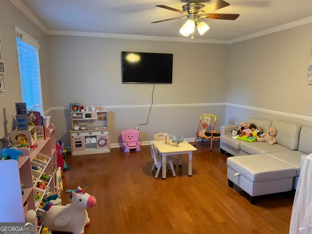 a playing room with furniture and a flat screen tv
