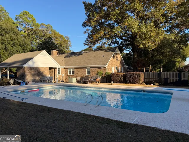 a view of a house with pool and chairs