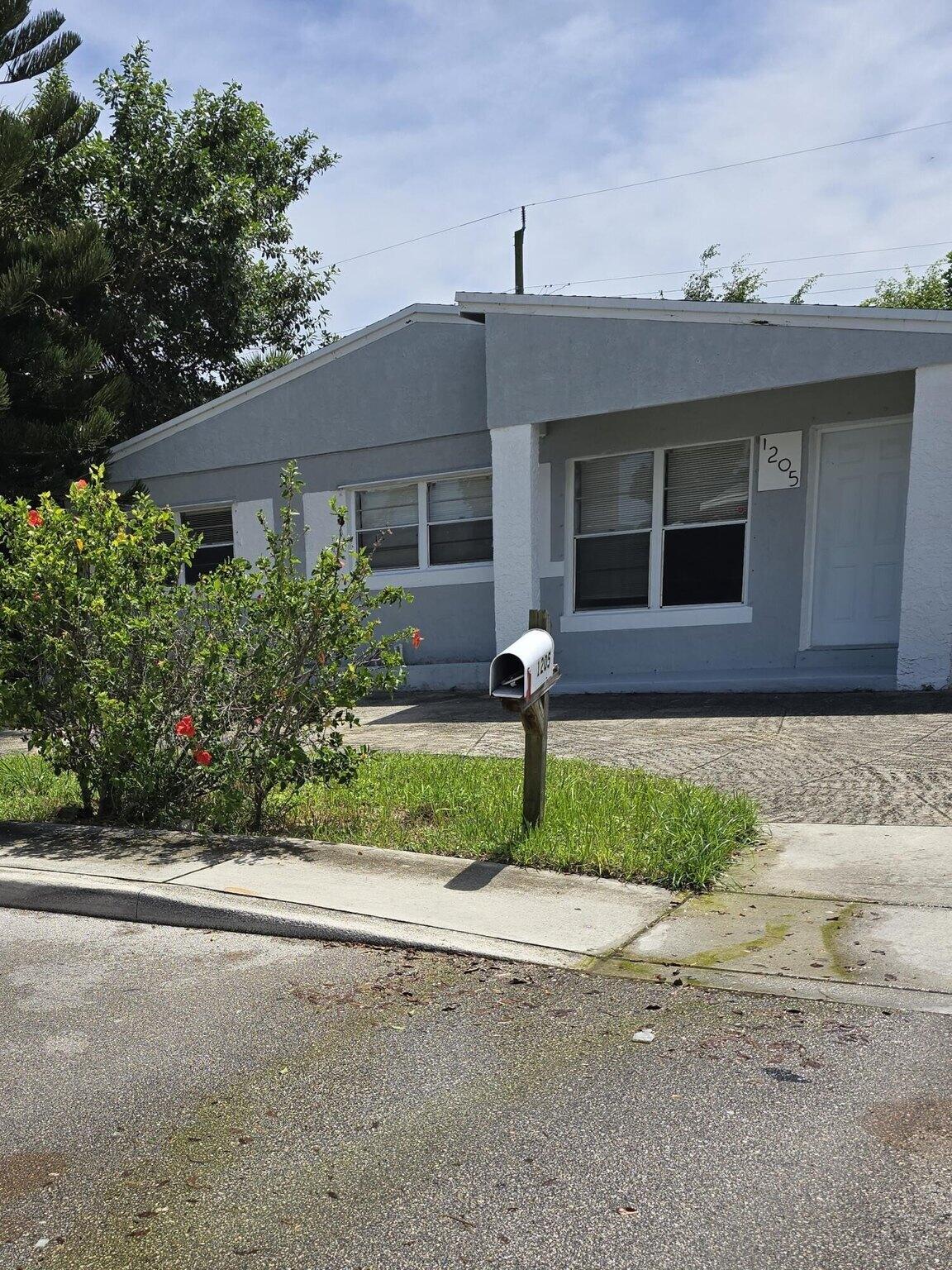 1205 West 24th Street Riviera Beach, FL 33404 - Photo 1 of 11 a front view of a house with a yard and garage