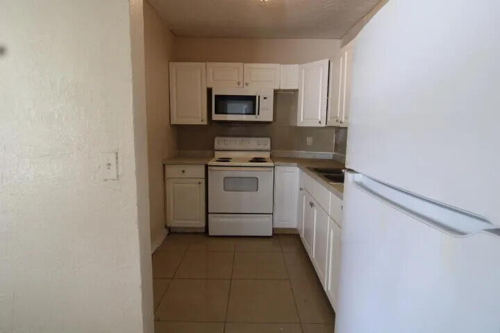 1205 West 24th Street Riviera Beach, FL 33404 - Photo 2 of 11 a kitchen with a sink stove and microwave