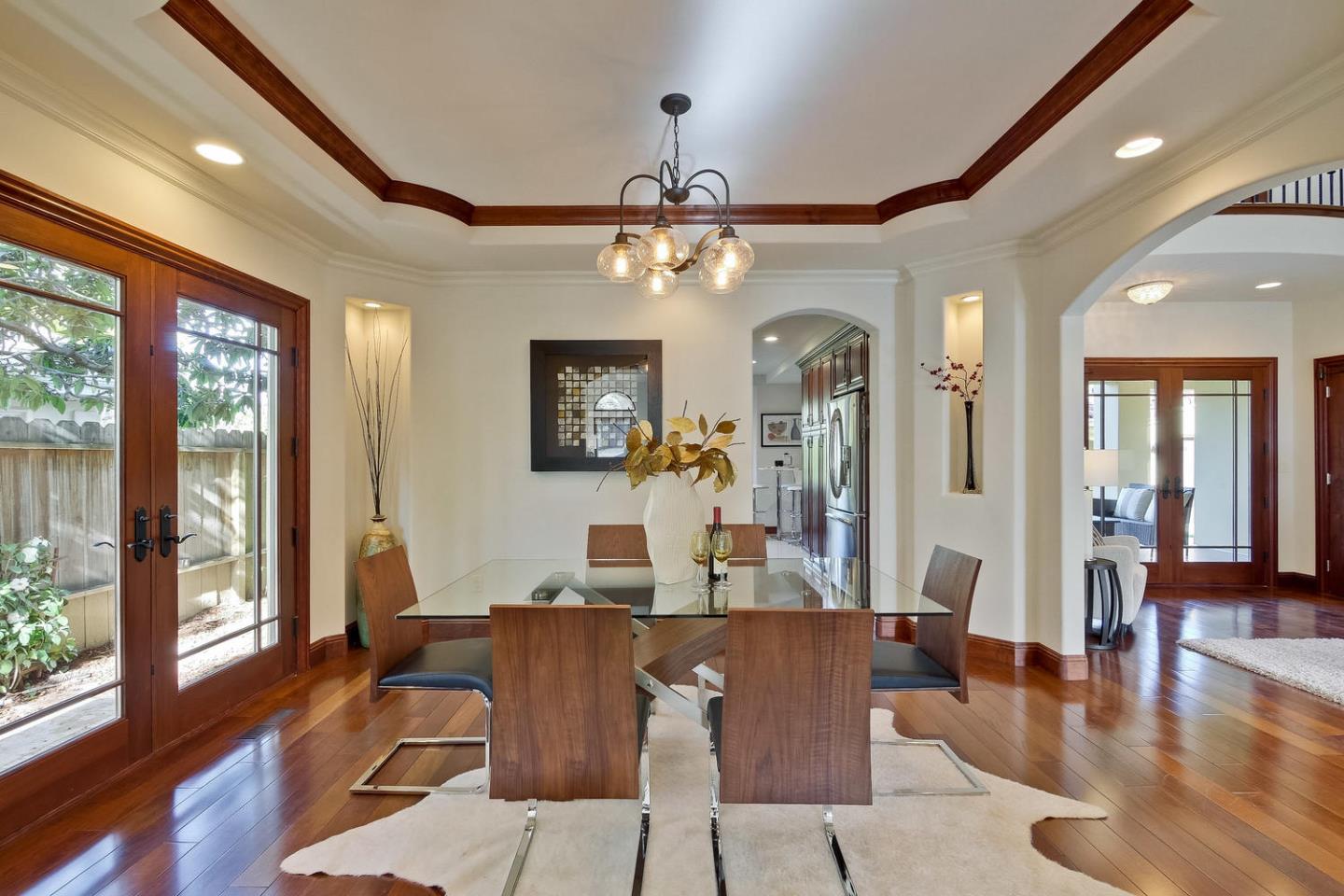 1725 Newell Road Palo Alto, CA 94303 - Photo 12 of 47 a dining room with wooden floor a chandelier a glass table and chairs