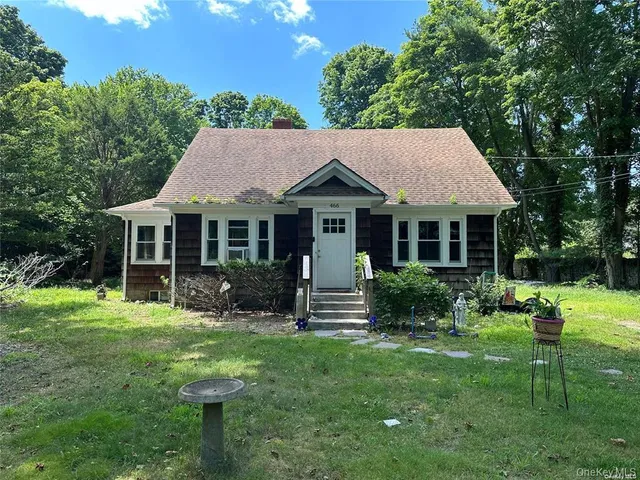 a front view of a house with a yard table and chairs