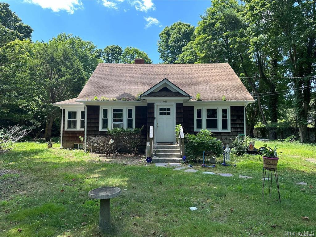 a front view of a house with a yard table and chairs