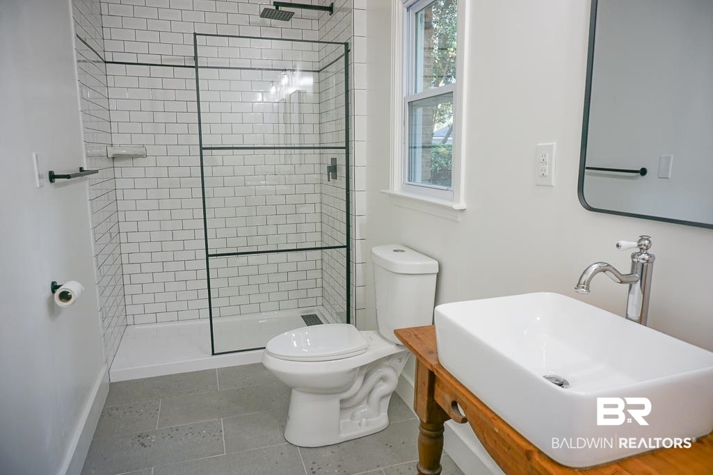 6205 Zeigler Boulevard Mobile, AL 36608 - Photo 13 of 17 Full bathroom featuring tiled shower, tile patterned flooring, and vanity