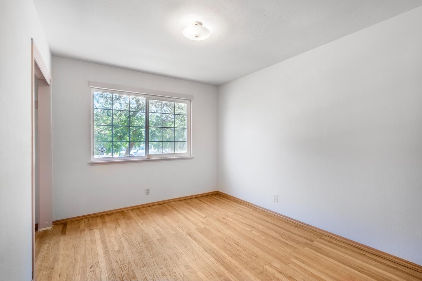 421 Fairview Drive Gilroy, CA 95020 - Photo 12 of 23 an empty room with wooden floor and windows