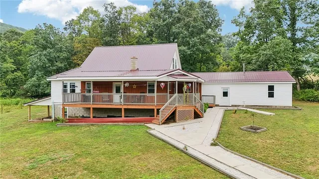 a view of a house with pool and a yard