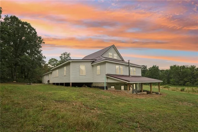 a aerial view of a house next to a big yard and large trees