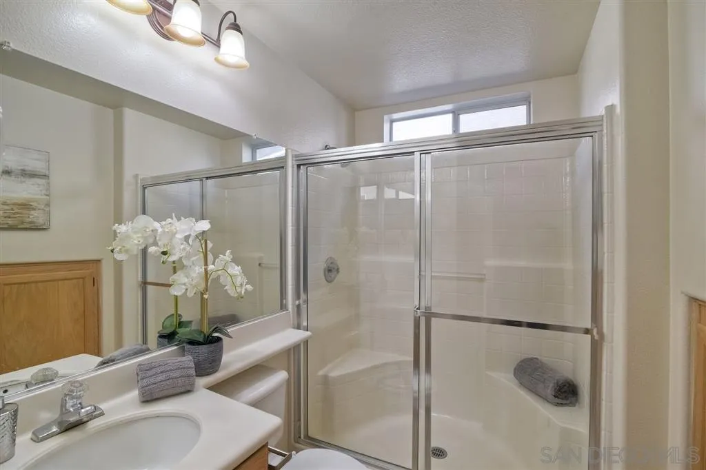 11574 Village Ridge Road San Diego, CA 92131 - Photo 13 of 25 a bathroom with a shower sink and mirror