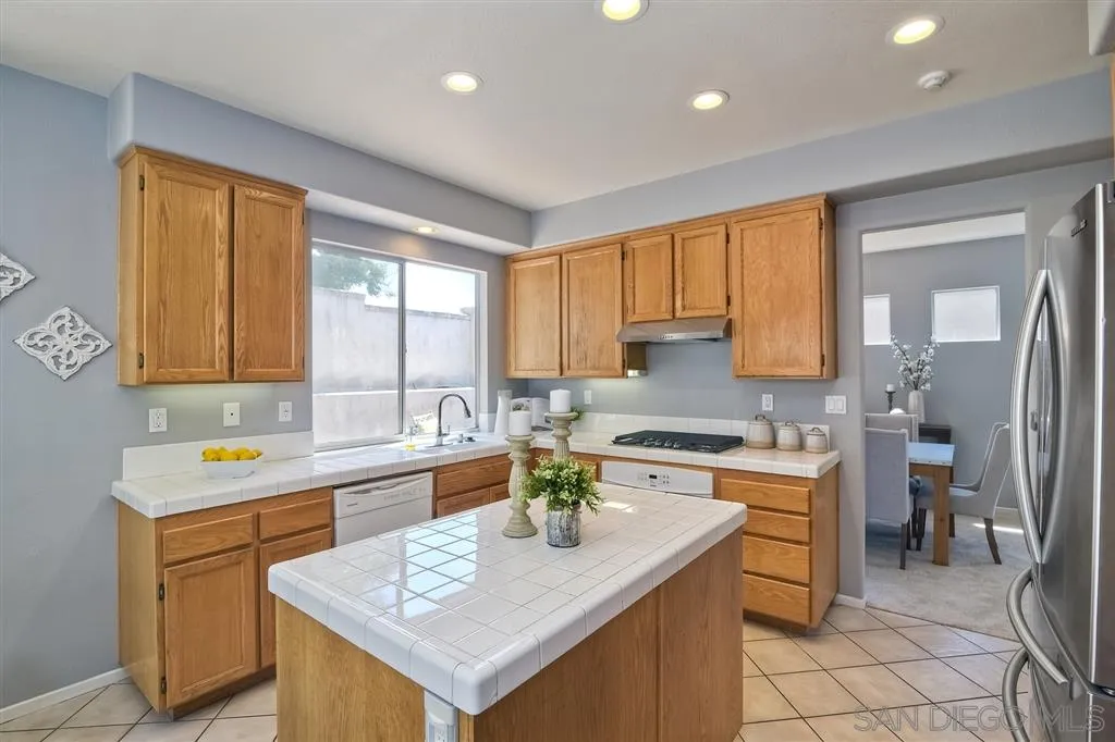 11574 Village Ridge Road San Diego, CA 92131 - Photo 7 of 25 a kitchen with a sink a counter top space and stainless steel appliances