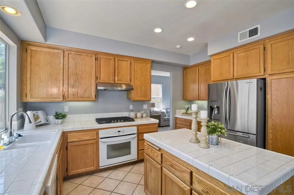 11574 Village Ridge Road San Diego, CA 92131 - Photo 8 of 25 a kitchen with a sink stove and refrigerator