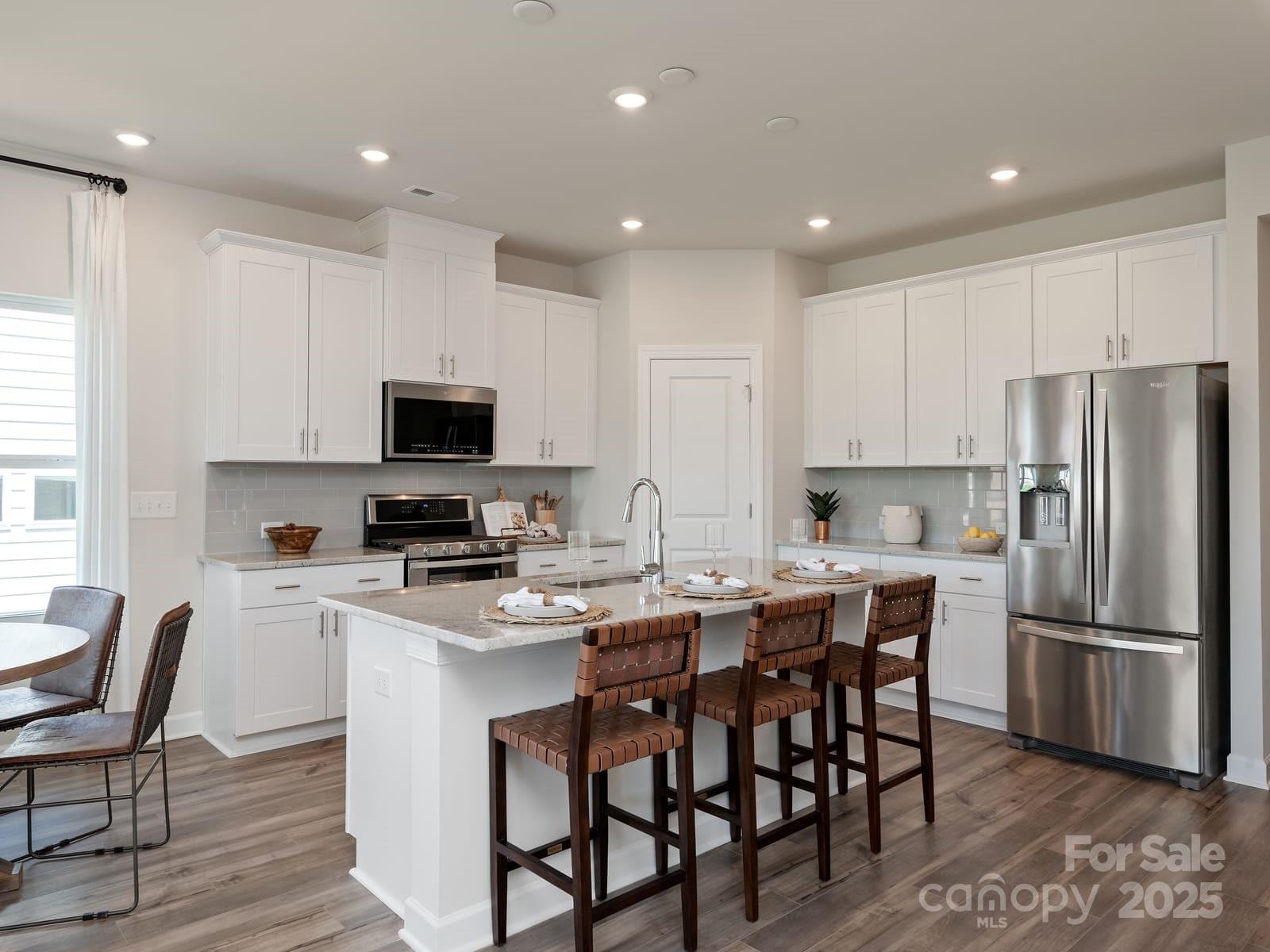 760 Palmer Pendleton Way York, SC 29745 - Photo 11 of 12 a kitchen with stainless steel appliances granite countertop a dining table chairs refrigerator and microwave
