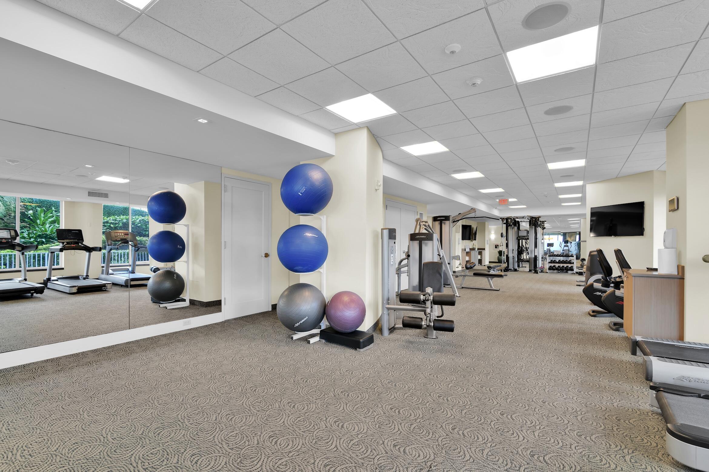 500 South Ocean Boulevard, Unit 1905 Boca Raton, FL 33432 - Photo 62 of 73 a room with gym equipment and a large window with the potted plants on the wall