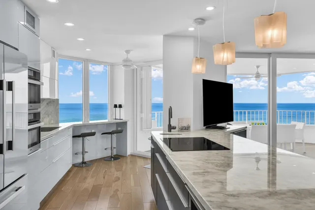 a living room with furniture a flat screen tv and a floor to ceiling window