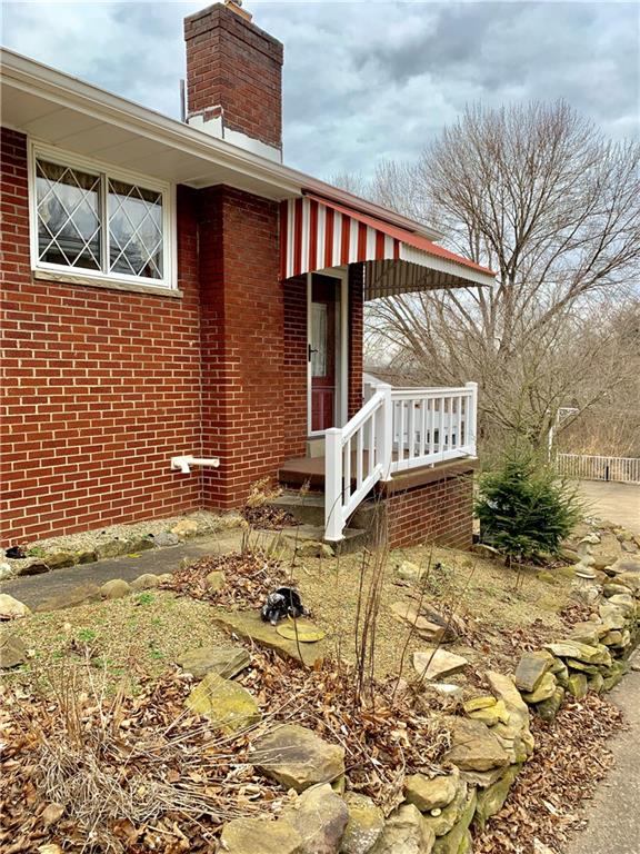 634 Deer Lane Extension Rochester, PA 15074 - Photo 22 of 25 Side entrance to the kitchen/basement area. Stoned edged landscape beds anyone with a green thumb will appreciate.