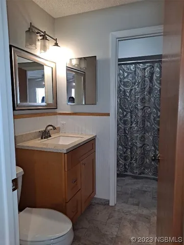 a bathroom with a granite countertop toilet sink and mirror