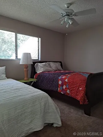a bedroom with two large bed and a large window