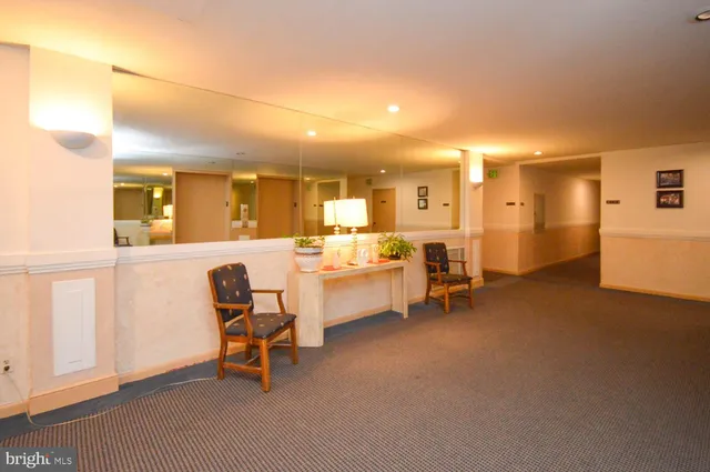 a living room with furniture and a dining table with projector the screen