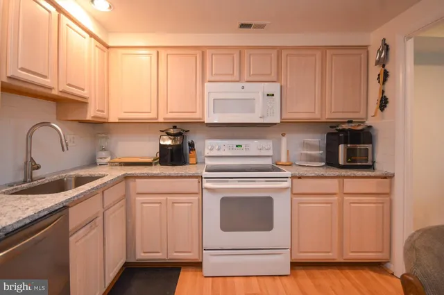 a kitchen with white cabinets and white appliances