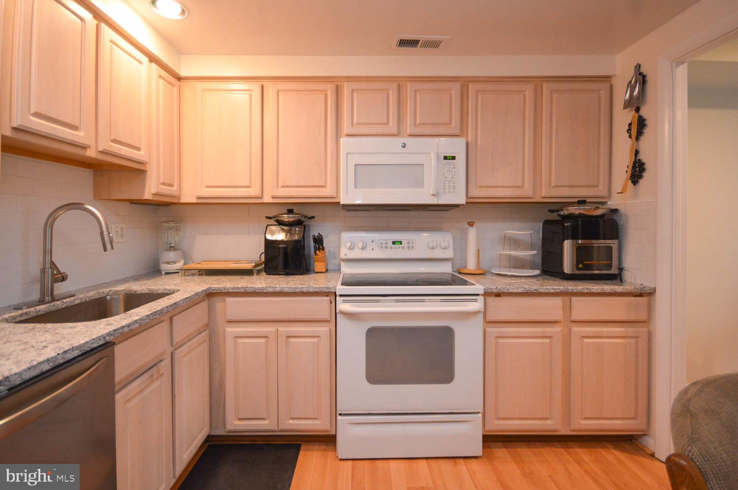 6317 Park Heights Avenue, Unit 310 Baltimore, MD 21215 - Photo 22 of 37 a kitchen with white cabinets and white appliances